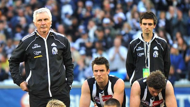 The fallen: coach Mick Malthouse (left) stands beside his players after the loss yesterday.