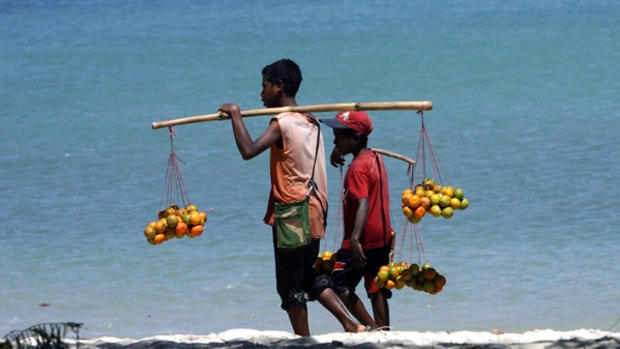 Young vendors look to sell their wares on a beach in Dili.