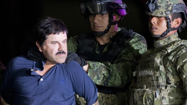 Joaquin "El Chapo" Guzman is made to face the press as he is escorted to a helicopter in handcuffs by Mexican soldiers.