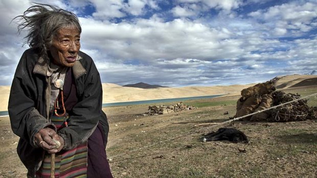 Resonant: A woman wears a medallion with the forbidden image of the Dalai Lama in Ladakh, India by Paula Bronstein.