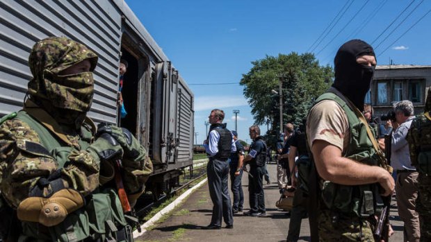 Alexander Hug (centre), Deputy Chief Monitor of the Organisation for Security and Cooperation in Europe (OSCE) Special Monitoring Mission to Ukraine, visits a train containing the bodies of victims of the MH17 crash in Torez, Ukraine as pro-Russia rebels guard the site.