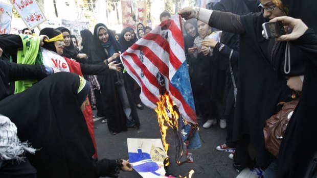 Iranian female demonstrators burn a representation of the US flag and a caricature of President Barack Obama.