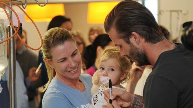 David Beckham signs an autograph for 19 month old Allegra Fewson Ward as her mother Jacqui Fewson looks on at the Royal Childrens Hospital.