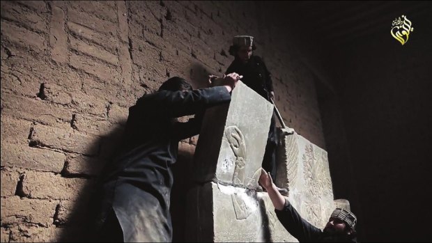 An image taken from a video made available by jihadist media allegedly shows members of Islamic State destroying a stone slab at what they said was the ancient Assyrian city of Nimrud in northern Iraq. 