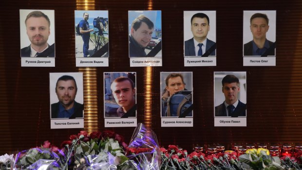 Flower tributes in front of portraits of Russian TV journalists who were killed in the crash.
