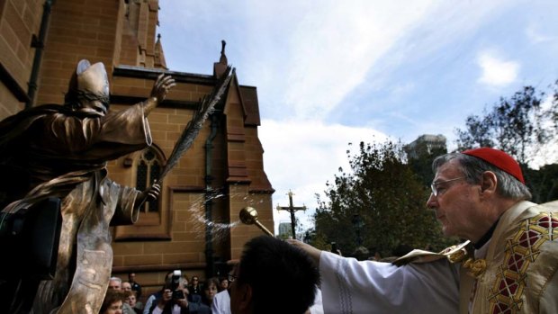 Historic Event ... Cardinal George Pell blesses a statue of Pope John Paul II outside St Mary's Cathedral yesterday