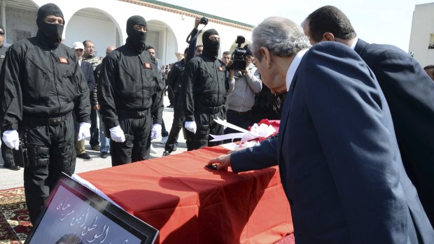 Tunisian ministers touch the coffin of elite security member Aymen Morjen, who was killed in the attack.