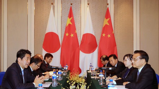 Japanese Prime Minister Shinzo Abe, left, speaks to Chinese Premier Li Keqiang, right, during a bilateral meeting held on the sideline of the 11th Asia-Europe Meeting (ASEM) Summit in Ulaanbaatar, Mongolia.