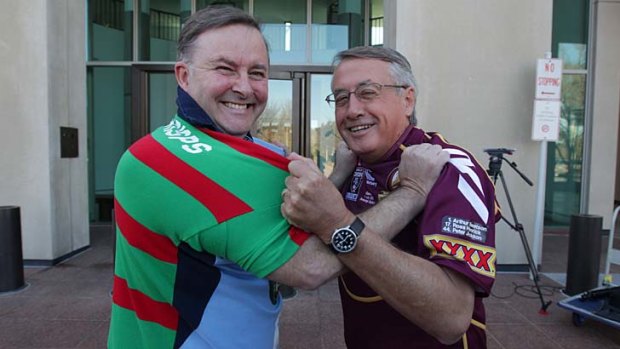 Wayne Swan and Anthony Albanese pictured in a friendly tussle ahead of a state of origin game earlier this year.