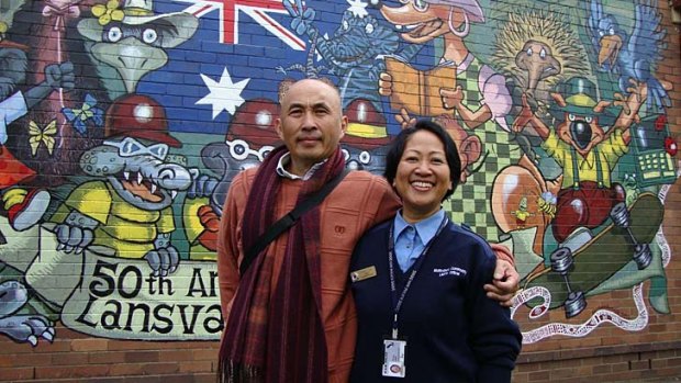A new life: Bun Heang Ung and his wife Phiny with one of his murals.