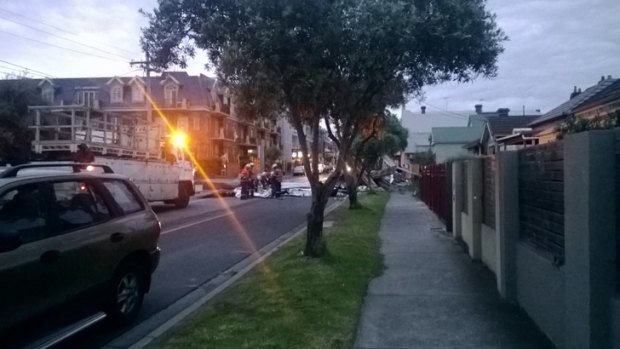 Emergency crews respond to wind damage on Maribyrnong Road at Ascot Vale, where witnesses say debris, possibly a roof ripped off a home, have brought down power lines.