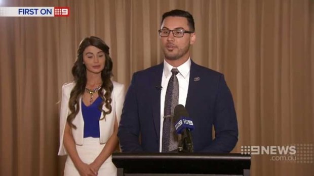 Salim Mehajer at a lectern, with his wife Aysha beside him, during his interview with Nine News.