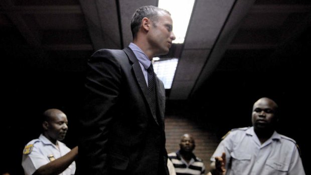 Henke Pistorius reaches out to his Olympic athlete son, Oscar, during his court hearing.
