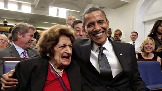 In this Aug. 4, 2009 file photo, President Barack Obama, marking his 48th birthday, takes a break from his official duties to bring birthday greetings to veteran White House reporter Helen Thomas, left, who shares the same birthday and turns 89, in the White House Press Briefing Room in Washington.