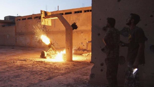 Rebel fighters launch a rocket towards forces loyal to Syria's President Bashar al-Assad in Deir al-Zor.