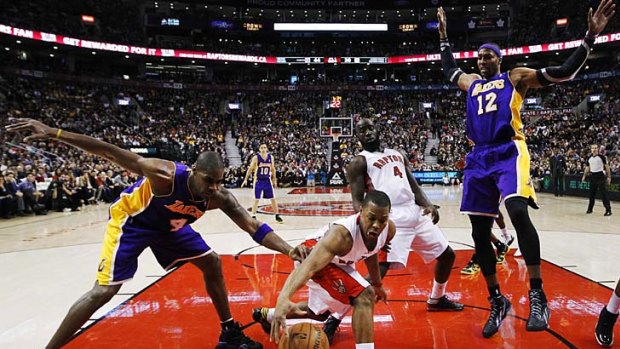 Toronto Raptors' Kyle Lowry (centre left) and Quincy Acy (center right) battle for the ball with Los Angeles Lakers' Antawn Jamison (4) and Dwight Howard (12).