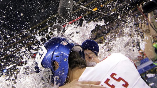 New York Giants kicker Lawrence Tynes hugs head coach Tom Coughlin at the end of the NFL Super Bowl XLVI football game against the New England Patriots.