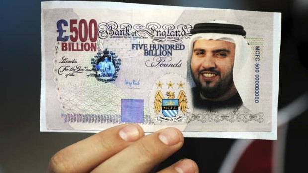 A different world: A fan holds a Manchester City 'banknote'.