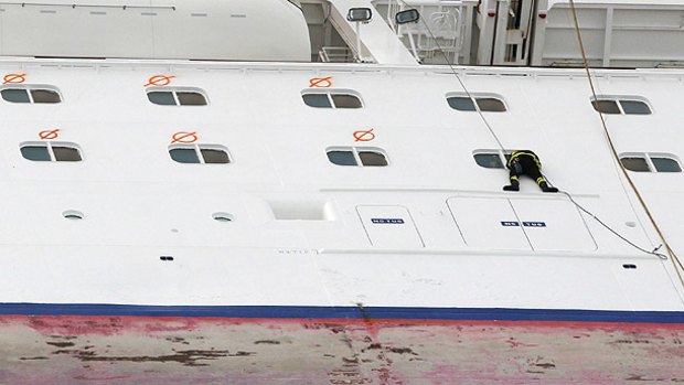 A firefighter looks into a cabin window on the side of the Costa Concordia cruise ship as the search for bodies continues.