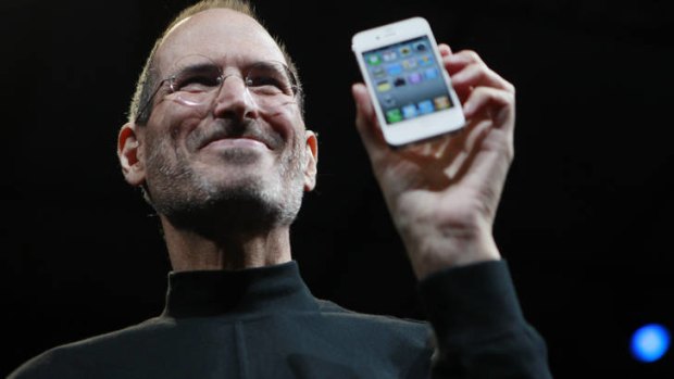 The late Steve Jobs holds an iPhone.