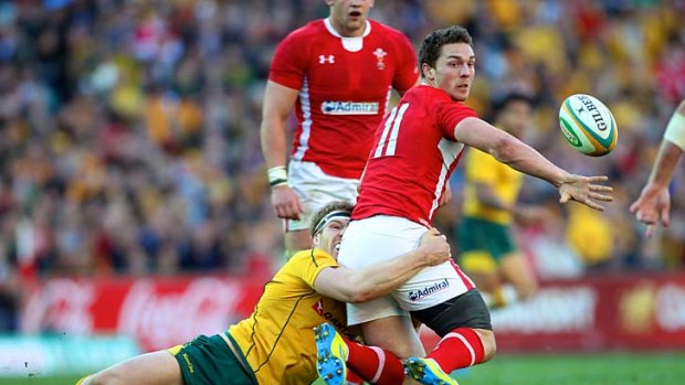 Wallabies captain David Pocock gets a grip on Welsh winger George North but cannot prevent the latter getting his pass away.