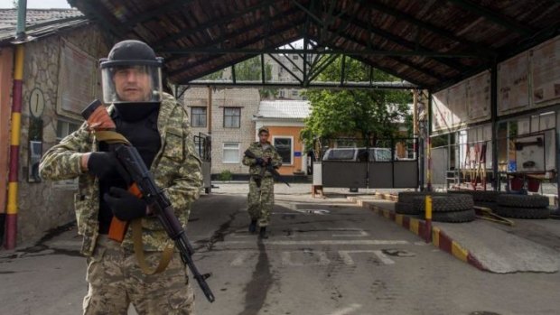 Win for separatists ... Pro-Russian militia men walk in an entrance to a border guards base, which they seized, on the outskirts of Luhansk, Ukraine.