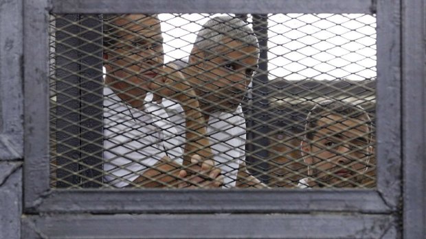 Caged in court room: Al Jazeera journalists (left to right) Peter Greste, Mohammed Fahmy and Baher Mohamed.