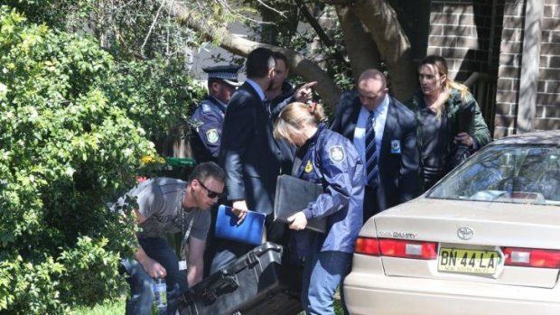Police carry away evidence after a raid in Marsfield, Sydney on Thursday.
