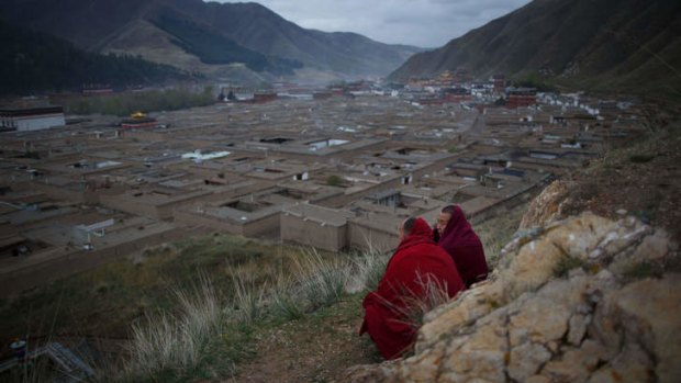 Two monks sit on a hillside overlooking the Labrang monastery in Xiahe, Gansu province, a flashpoint for many Tibetan protests against Chinese authorities.