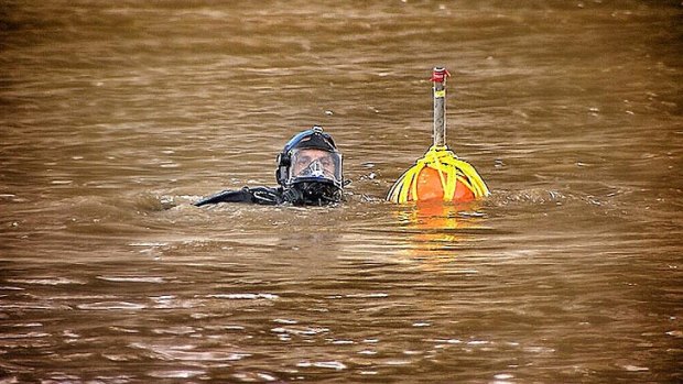 A police diver searches for clues in the Brisbane River on Monday.