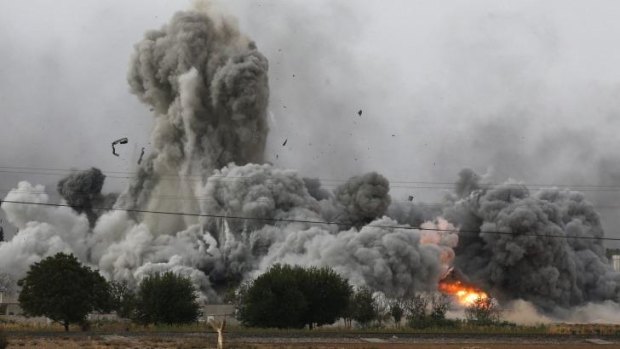 Too little, too late: Smoke, debris and fire rise in Kobane after an air strike by the US-led coalition.