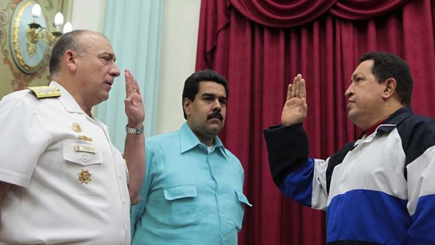 Nicolas Maduro (centre) at a swearing-in with Hugo Chavez (right).