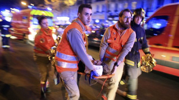 A woman is evacuated from the Bataclan theatre in Paris on Friday night. 