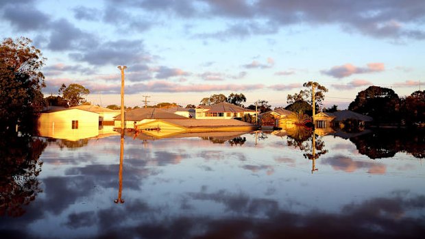 The sun rises over flooded streets as parts of southern Queensland experiences record flooding in the wake of Tropical Cyclone Oswald.