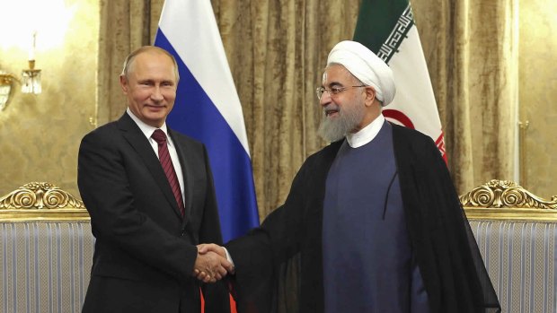 Iran's President Hassan Rouhani, right, shakes hands with Vladimir Putin during their meeting in Tehran on November 1.