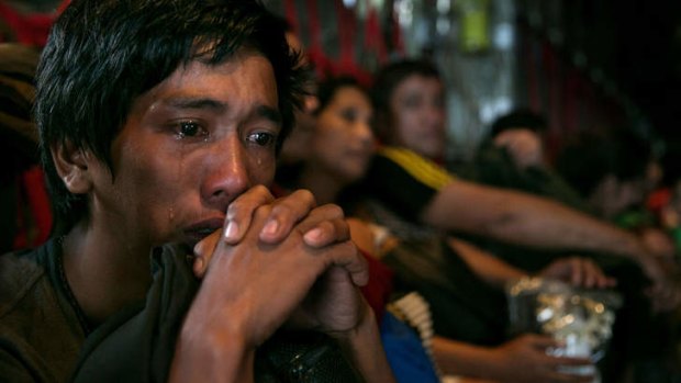 A man cries on a packed aircraft as he and hundreds of other victims of super typhoon Haiyan are evacuated from Tacloban in the Philippines.