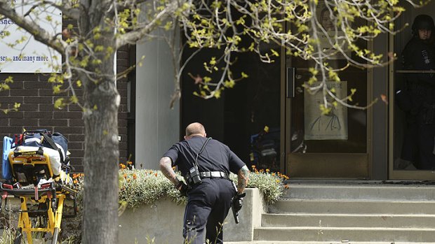 An Oakland police officer approaches the entrance to Oikos University in Oakland, California, where up to seven people have been shot dead
