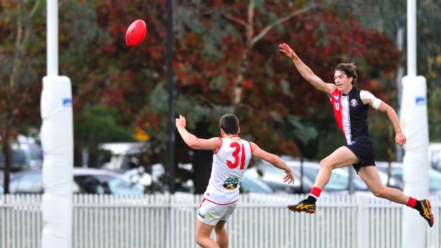 Sport.  NEAFL, Ainslie Vs Eastlake at Ainslie Oval.   Eastlake player Shae Darcy takes a kick at goal in front of Ainslie player Jordan Harper.  18 April 2015.  Canberra Times photo by Jeffrey Chan.