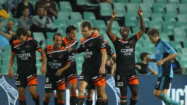 The Roar players celebrate their second goal against Sydney FC.