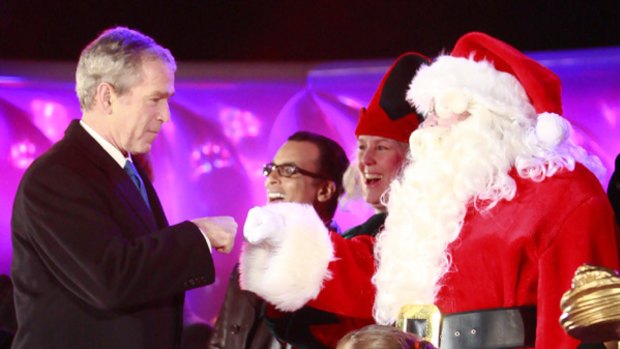US President George W. Bush makes a fist-bump greeting with Santa Claus during a lighting ceremony for the National Christmas Tree in Washington.