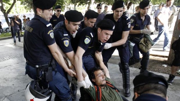 Police detain an anti-austerity protester during an operation to remove a small group of European demonstrators from central Syntagma square in Athens.
