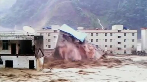 A building collapses amid a flood caused by torrential rain in Deyang City, Sichuan Province.