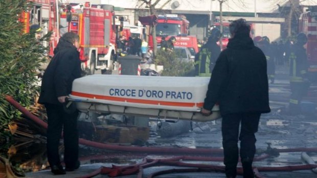 Two men carry a coffin after a fire broke out in a Chinese-run garment factory in Prato, near Florence, Italy.