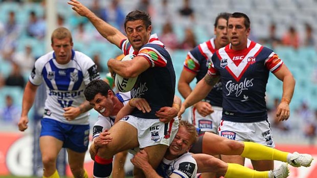 Mini me . . . Rooster Anthony Minichiello is tackled by Bulldogs Michael Ennis, horizontal, and David Stagg yesterday.