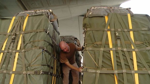 A Royal Australian Air Force loadmaster checks bundles of humanitarian aid prior to the airdrop.