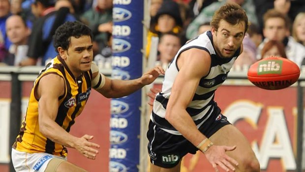 Neck and neck. Geelong's Corey Enright and Hawthorn's Cyril Rioli.