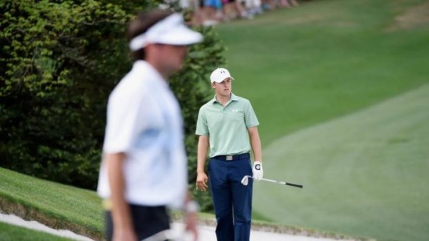 Jordan Spieth of the United States reacts to a bunker shot on the tenth hole as Bubba Watson looks on.