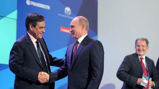 Russian President Vladimir Putin, centre,  shakes hands with former French Prime Minister Francois Fillon. Mr Putin was hopeful a plan for the destruction of Syrian chemical weapons would work.
