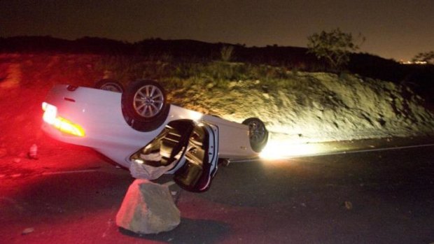 A car sits rolled over in the wake of Friday night's earthquake on Carbon Canyon Road in California.
