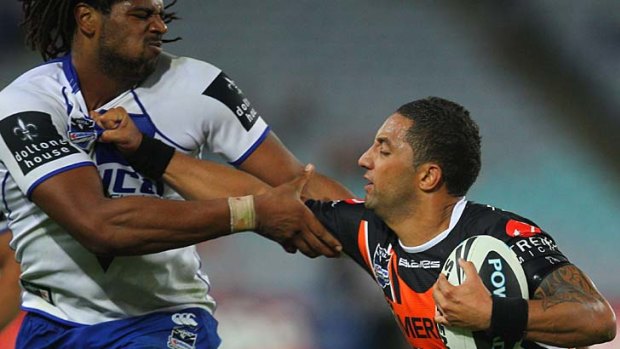 Arm wrestle . . . Tigers playmaker Benji Marshall runs into the formidable clutches of the Bulldogs' Jamal Idris.